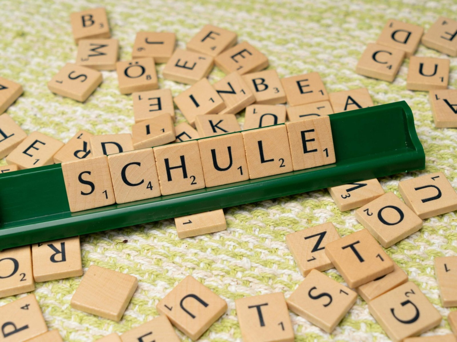 Word tiles spelling 'Schule' on table, ideal for language learning concepts.
