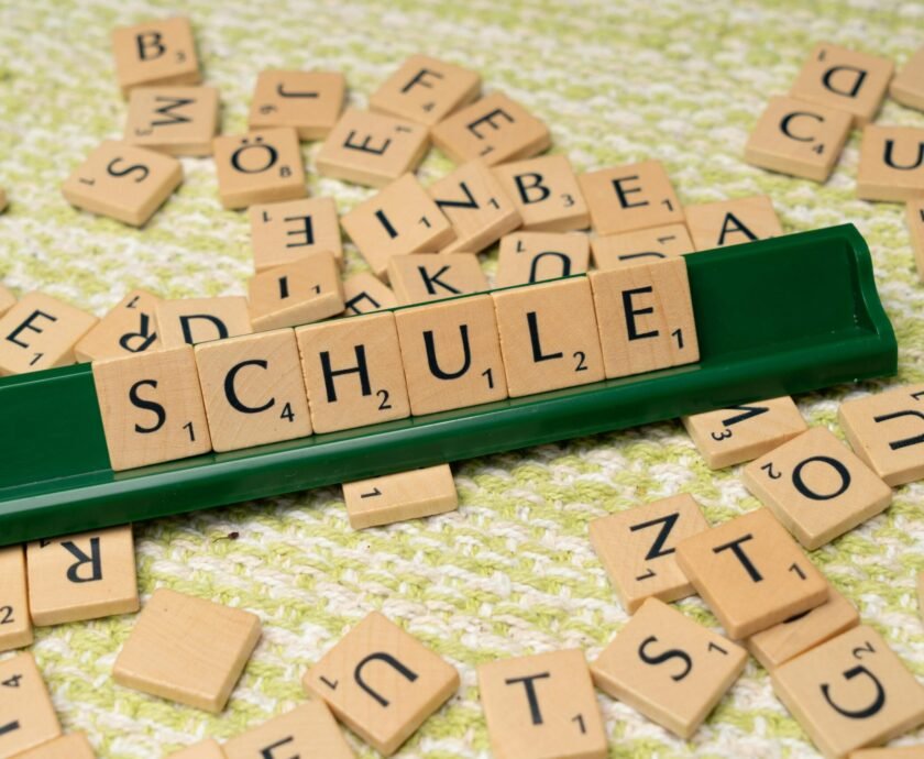 Word tiles spelling 'Schule' on table, ideal for language learning concepts.